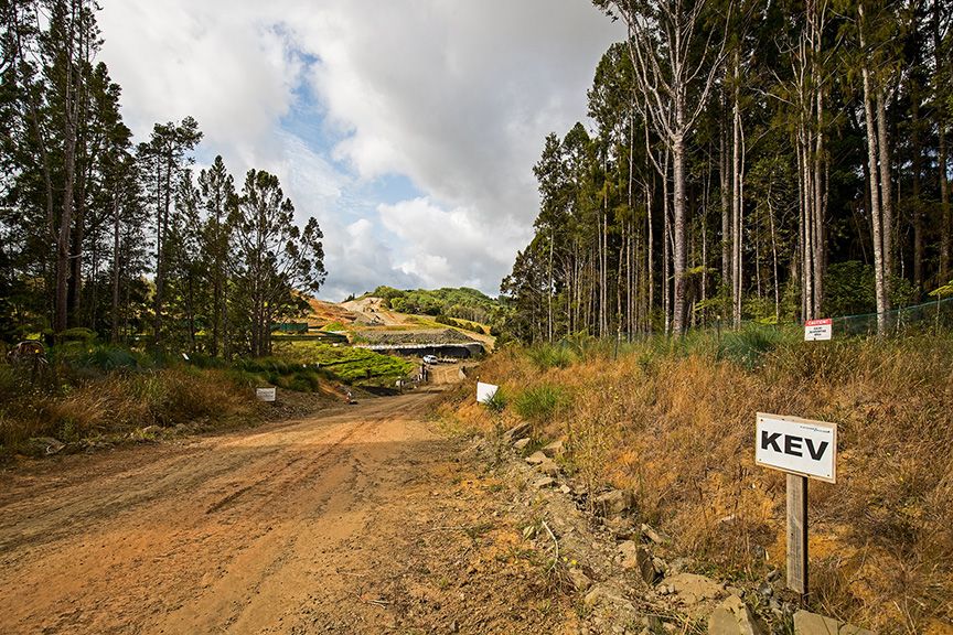 Construction site with a dirt road, trees, and a sign that says KEV.