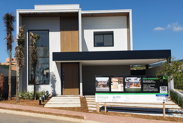 Modern two-story house with a white exterior, wooden accents, and a dark gray overhang.