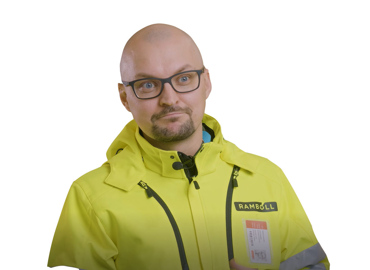 A man wearing a bright yellow jacket with the Ramboll logo on it, along with glasses, looks slightly to the side with a quizzical expression.