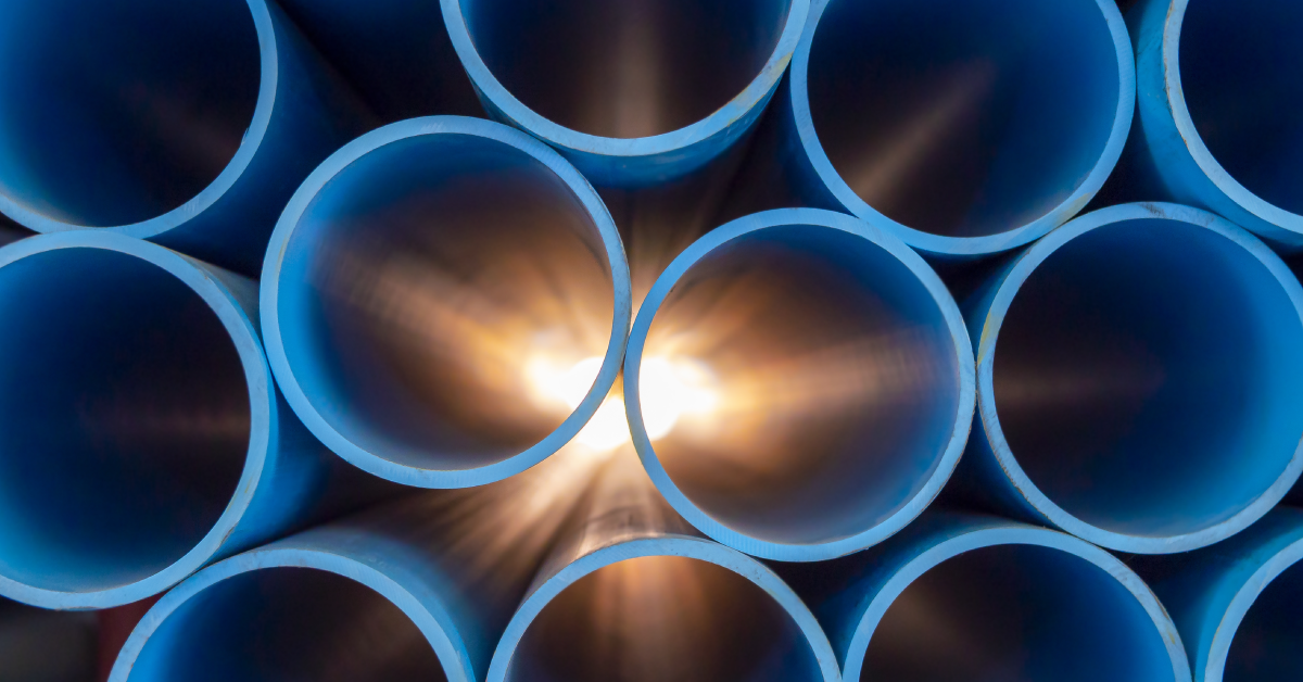 A close-up of stacked blue pipes with sunlight shining through the center.