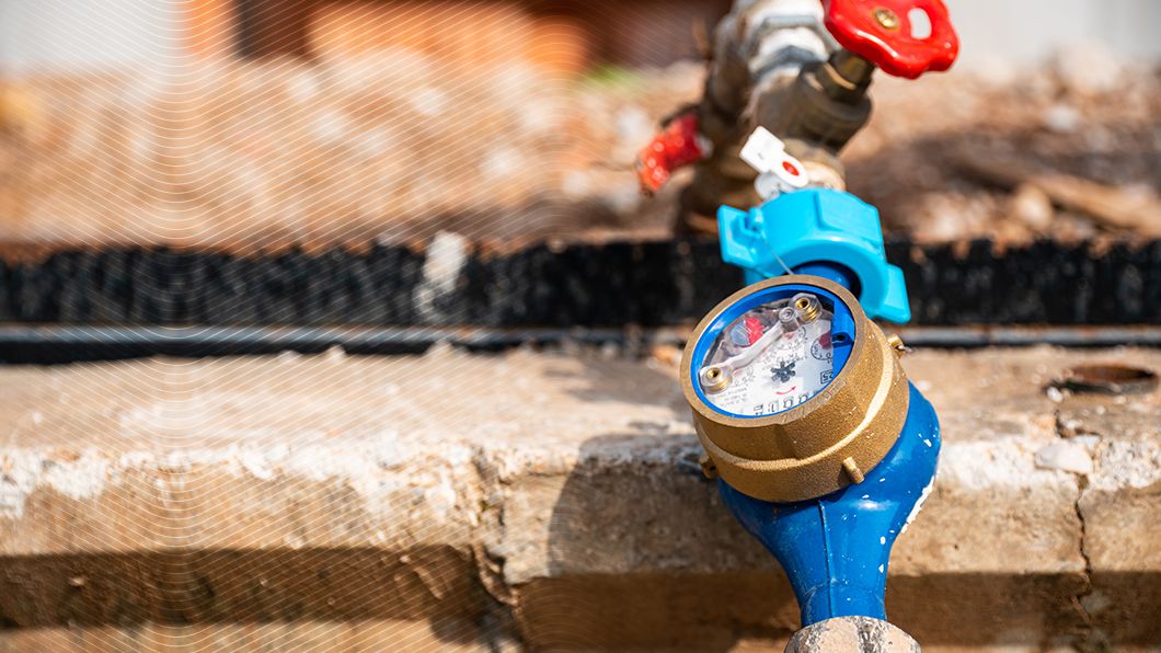 Brass & blue water meter, active m³ dial, red flow indicator, linked to blue pipes & red valve. Essential for utility monitoring.