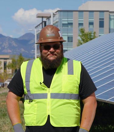 Vernon White in front of solar panels