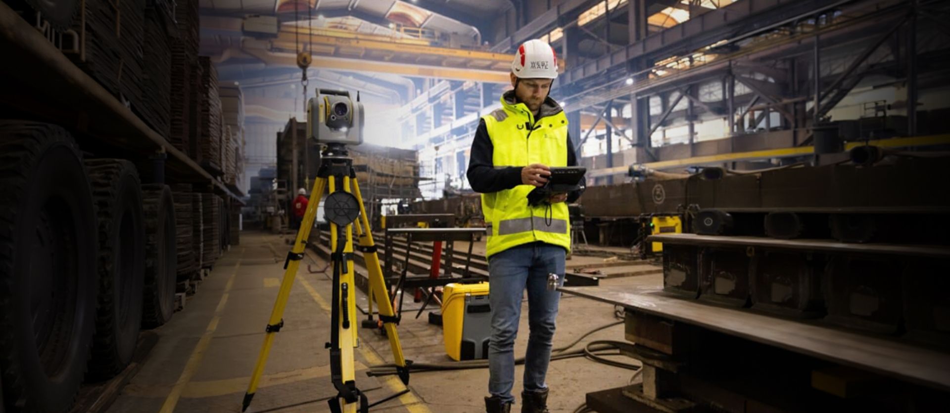 Man with data controller stands in a fabrication environment.