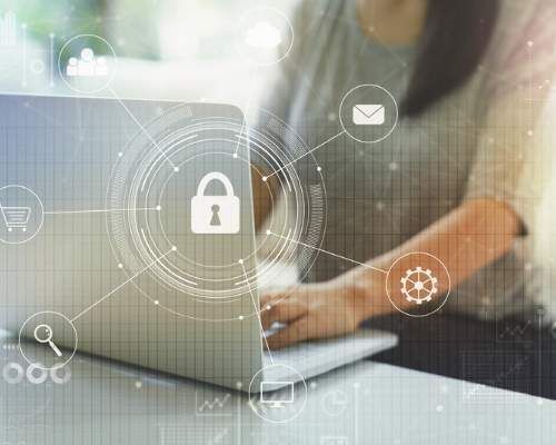 Digital security overlay of locks over a laptop with women's arms typing.