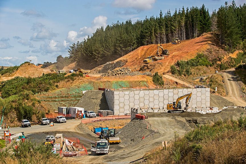 Construction site with heavy machinery and vehicles on a sunny day.
