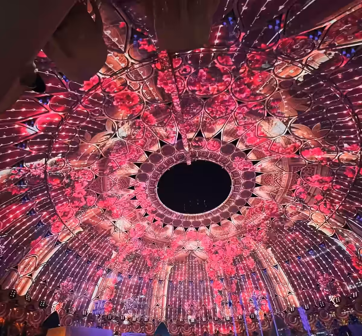 Spectacular illuminated dome interior with a crowd below.