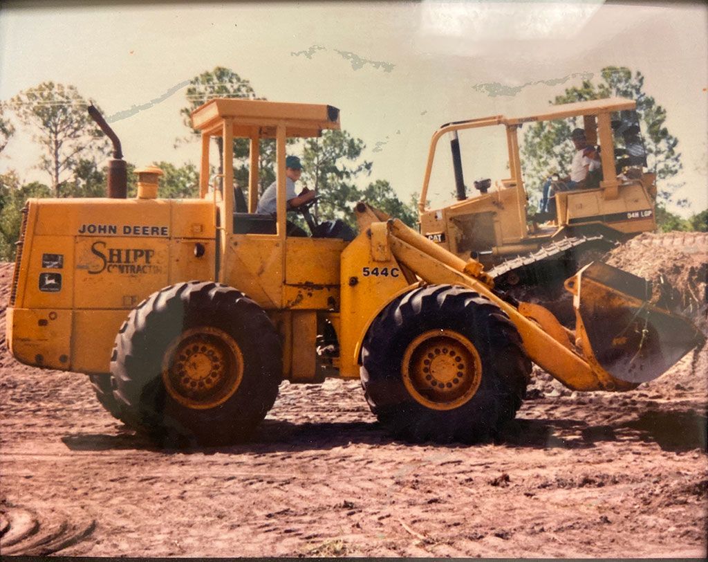 John Deere 544C wheel loader, operated by Shipp Contracts, is shown on a construction site.