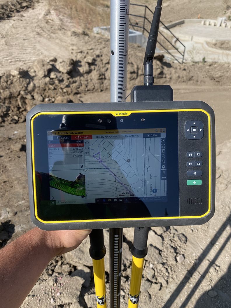 Trimble survey device showing a topographical map on its screen.