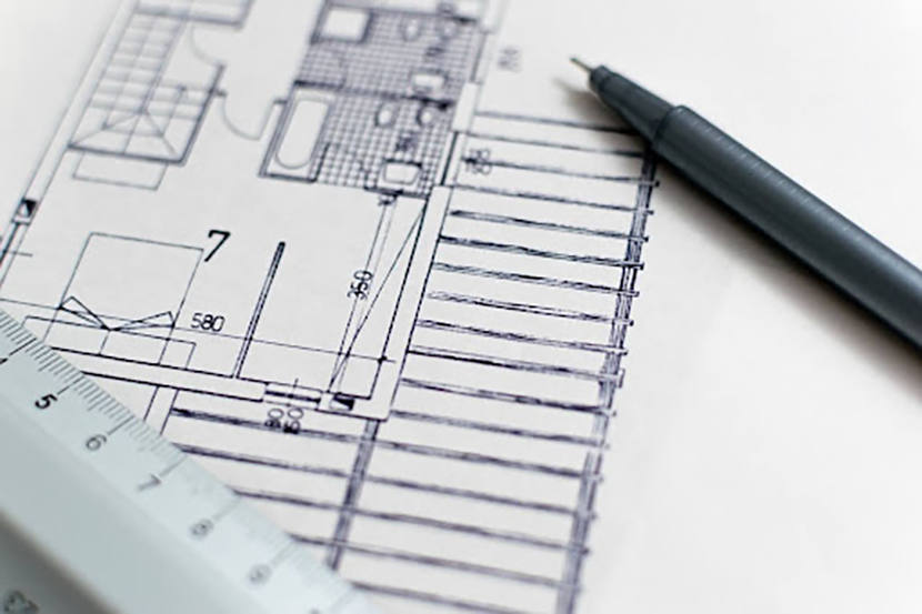 Close-up of a blueprint with a ruler and pen, indicating precision in 3D modeling.