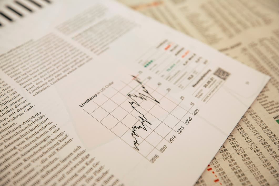 A graph showing fluctuating growth over several years is displayed on a document with financial tables in the background.