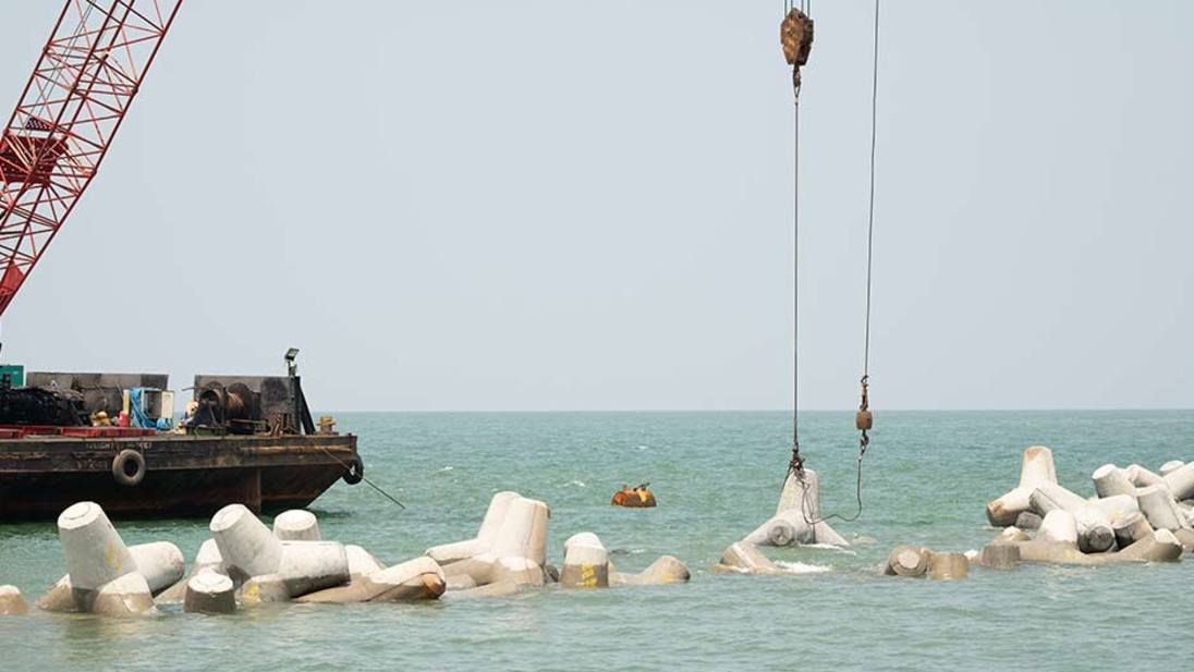 Crane placing tetrapod