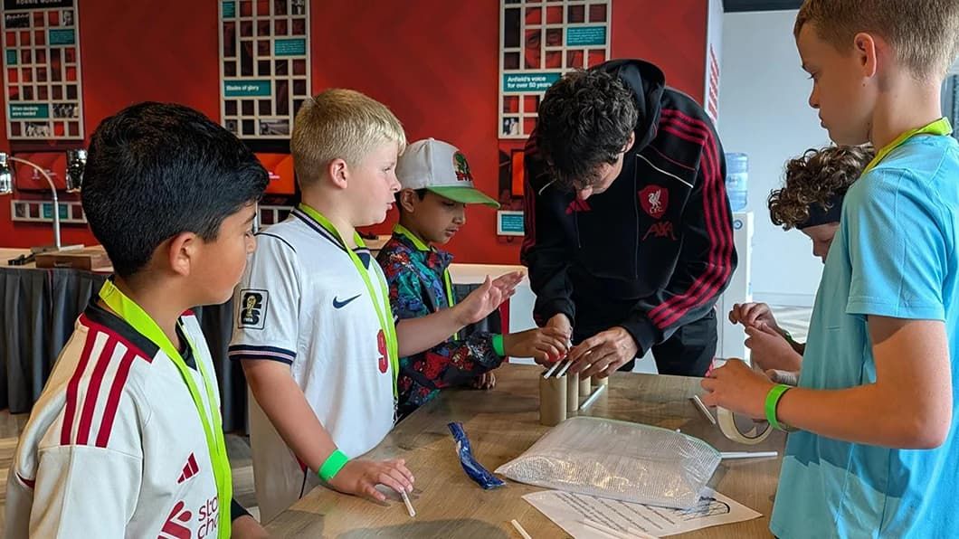 An instructor guides students assembling a model bridge during a Trimble LFC STEM session.