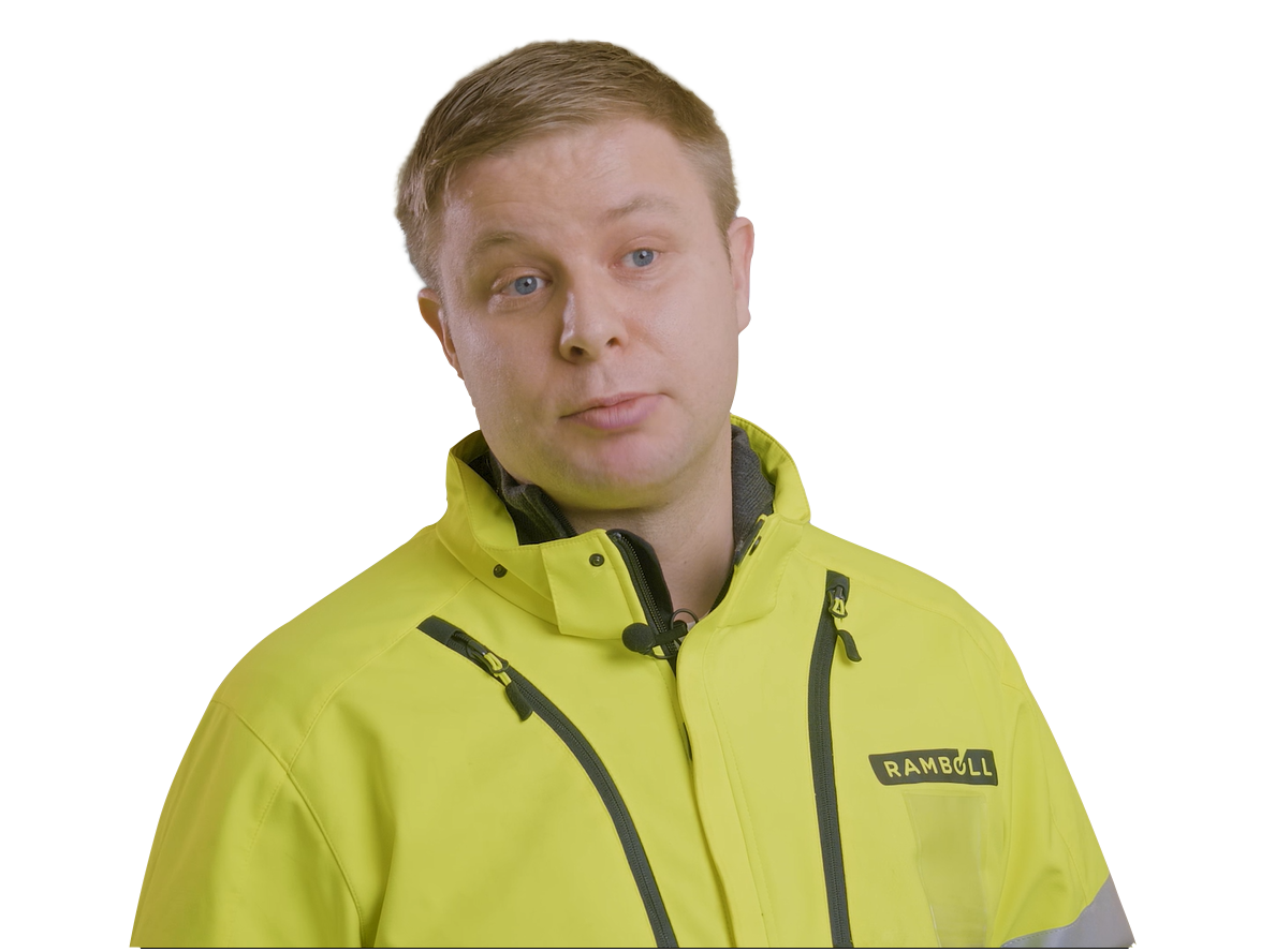 A man wearing a bright yellow Ramboll branded jacket and looking towards the camera.