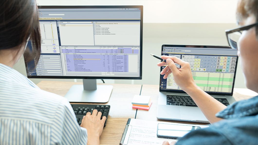 Professionals using Trimble MEP estimating software on dual monitors in an office setting.