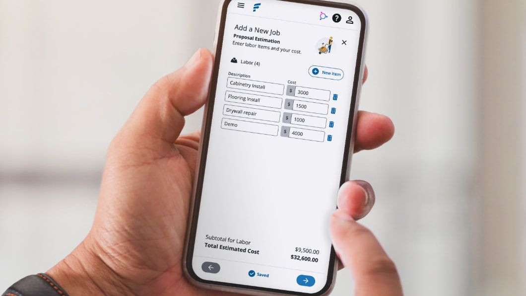 Hand holding a smartphone displaying a mobile Trimble Financials app screen showing estimating construction labor costs.