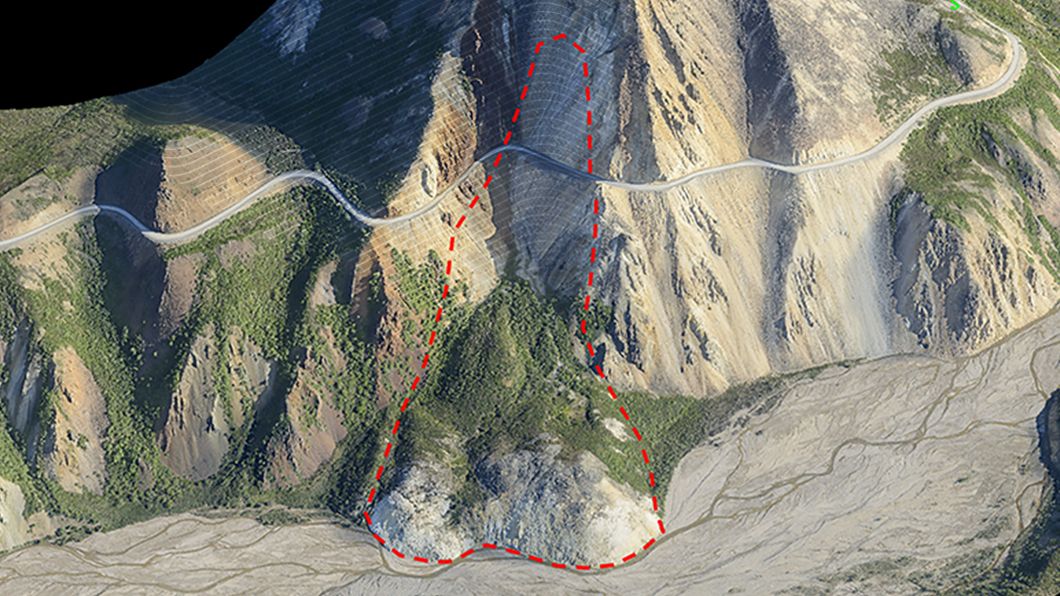 Aerial view of a mountain slope with a red dashed line indicating a potential landslide area