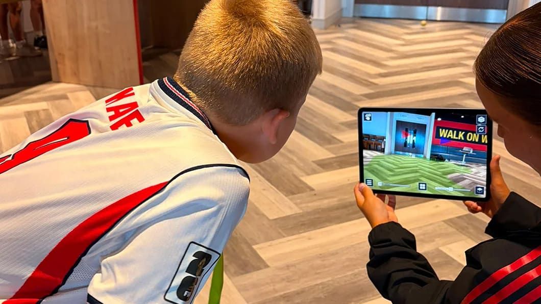 Two children view a 3D digital model on a tablet during a Trimble STEM workshop.