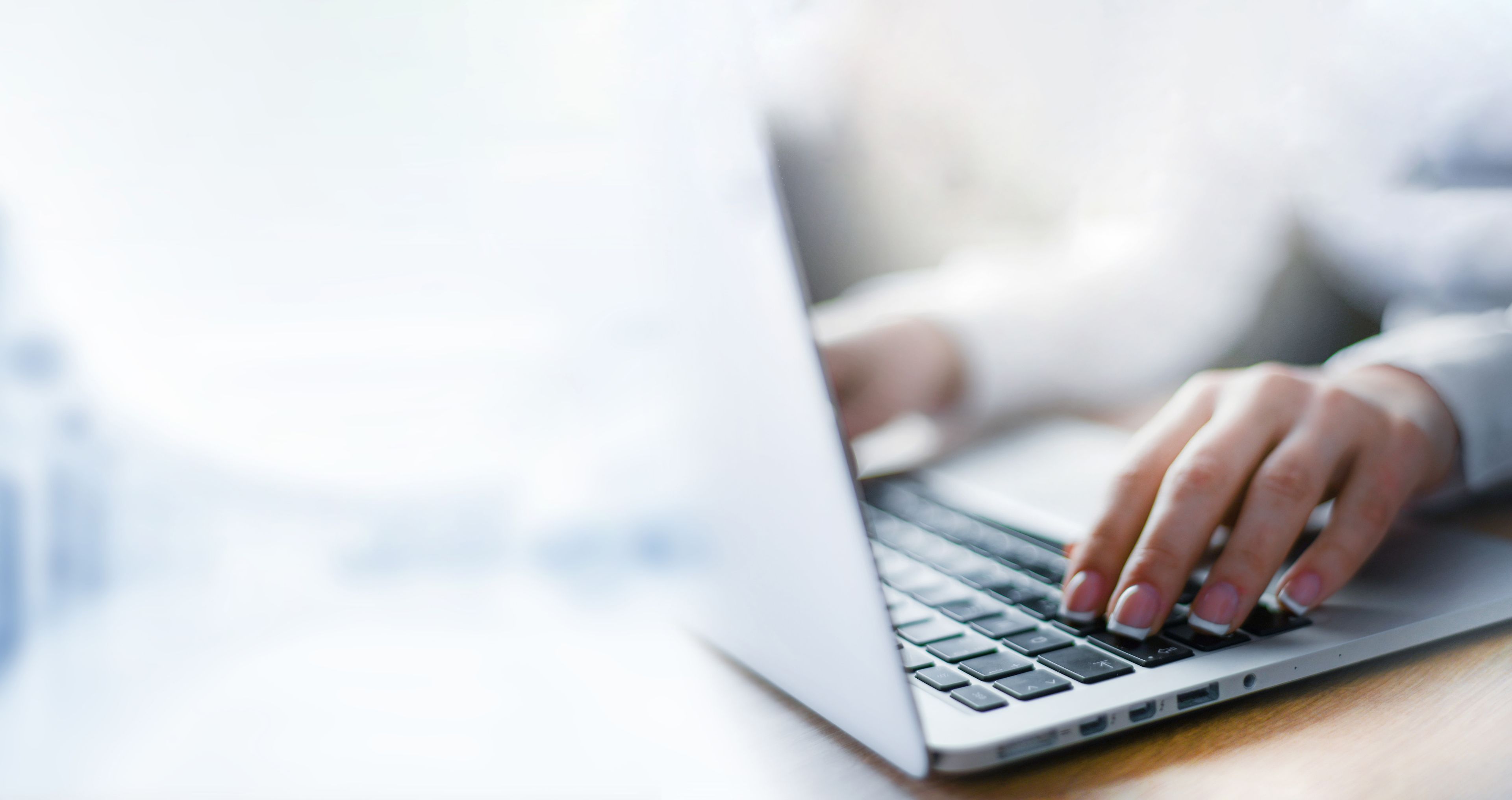 Close-up of a person's hands typing on a laptop computer.