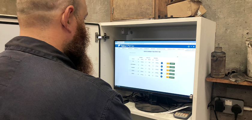 Waring Buildings employee sat at computer using Tekla EPM Go to update fabrication status of completed work