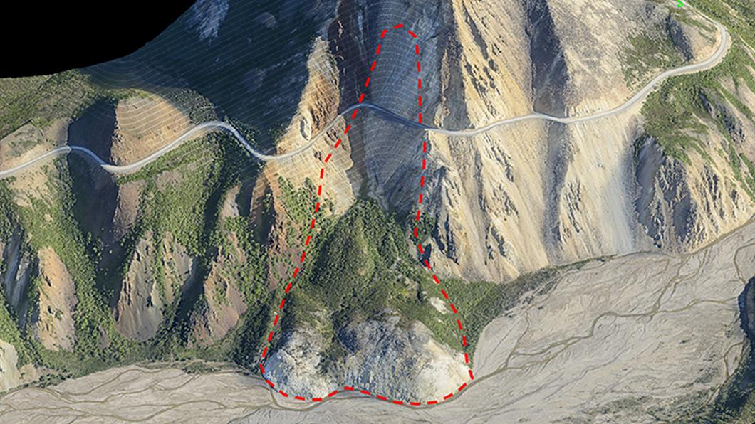 Aerial view of a mountain slope with a red dashed line indicating a potential landslide area