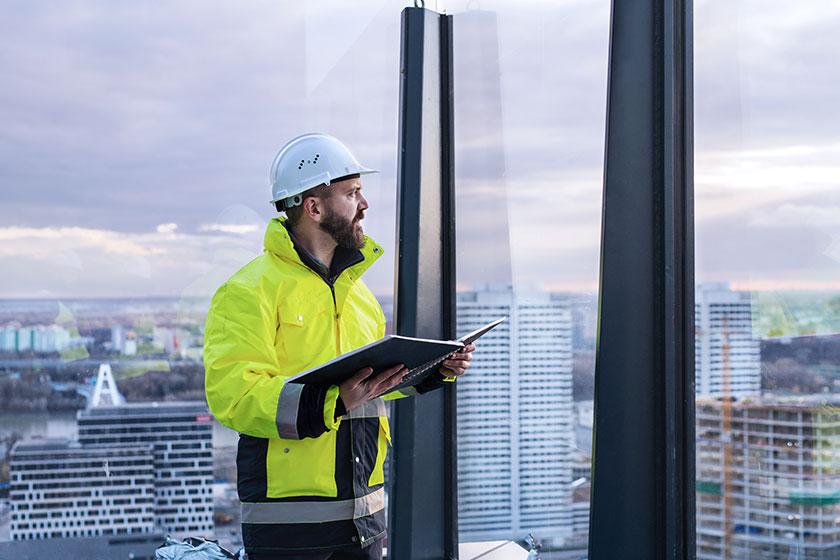 Builder checking plans at a highrise building