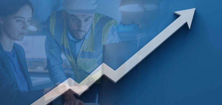 One office and one construction worker looking at a computer screen with a productivity graph