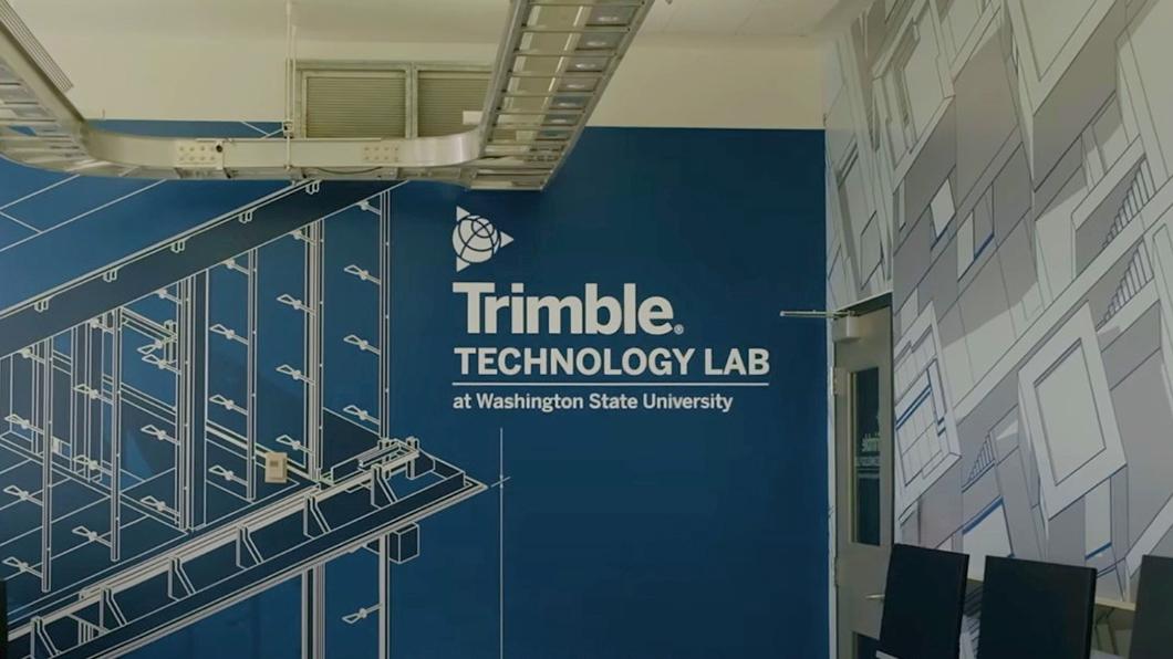Blue wall with white architectural drawings and "Trimble Technology Lab at Washington State University" text.
