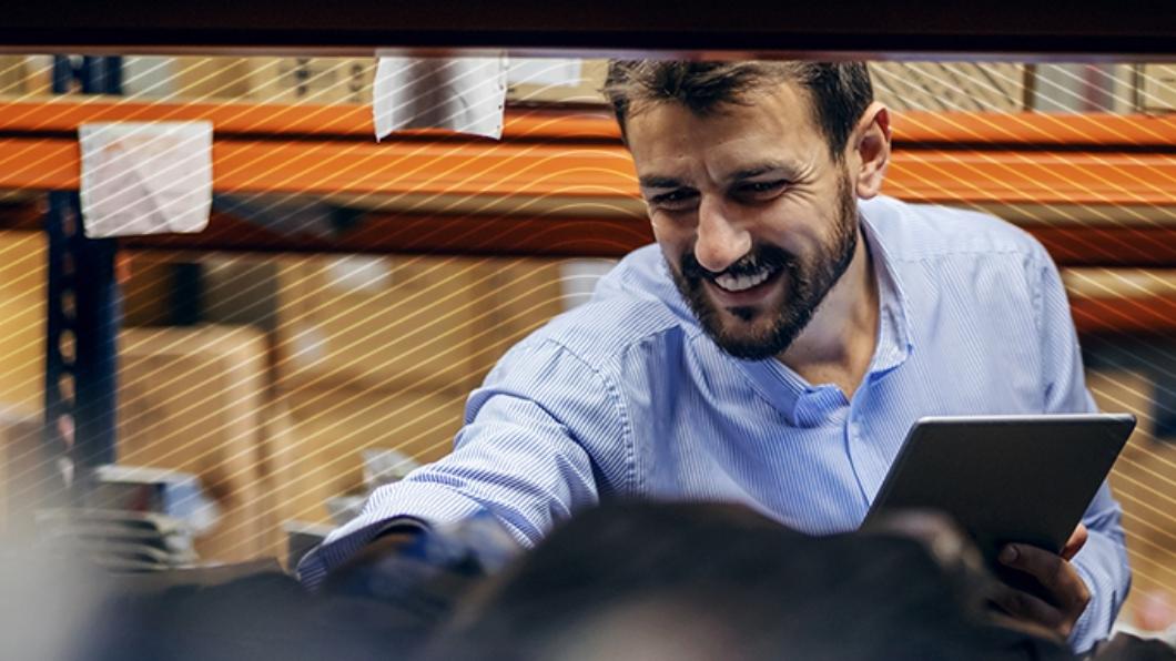 worker using a tablet inside a packed warehouse
